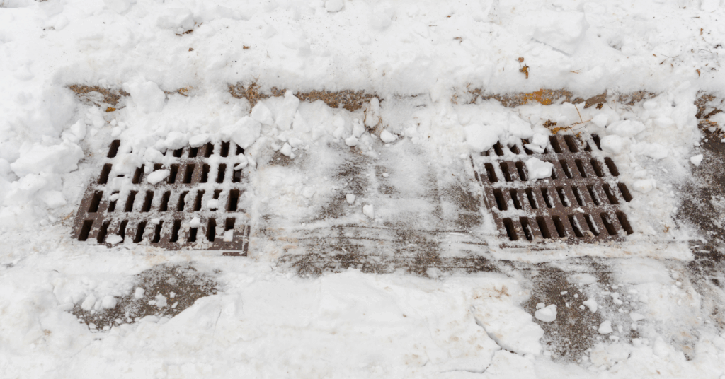 Stormwater drain covered in snow